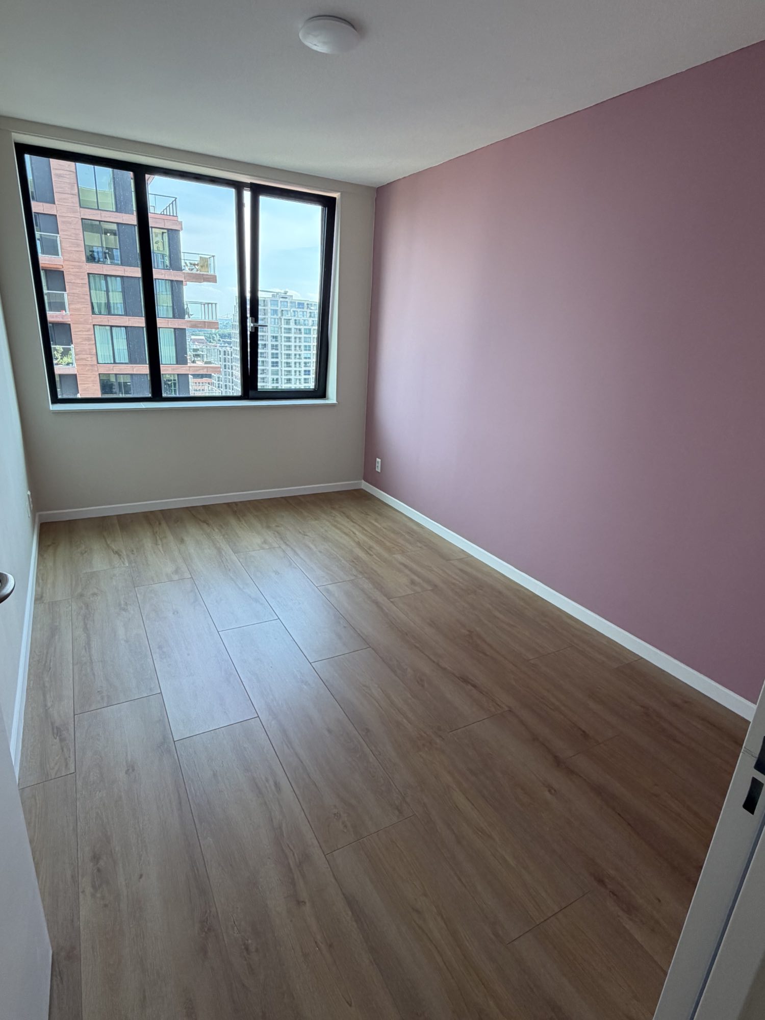 Slaapkamer met roze accentmuur geschilderd door Klussen Fixer